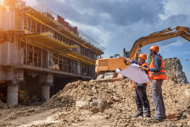 Engineers with blueprints at a construction site