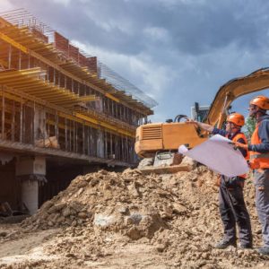 Engineers with blueprints at a construction site